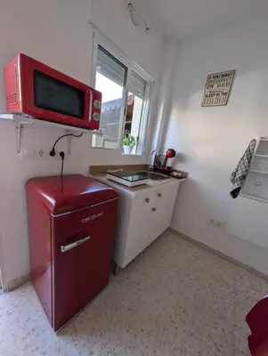 a small kitchen with a red refrigerator and a microwave at Aires de Sanlúcar in Sanlúcar de Barrameda