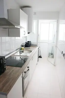 a white kitchen with a sink and a window at Coqueto encantador en el centro in El Puerto de Santa María