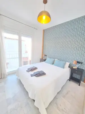 a bedroom with a large white bed and a window at Original y Coqueto en el Centro in El Puerto de Santa María