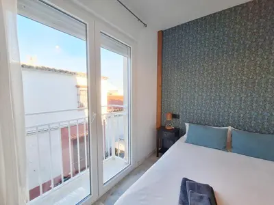 a bedroom with a bed and a large window at Original y Coqueto en el Centro in El Puerto de Santa María