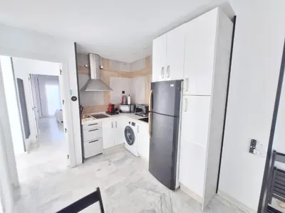 a kitchen with white cabinets and a refrigerator at Original y Coqueto en el Centro in El Puerto de Santa María