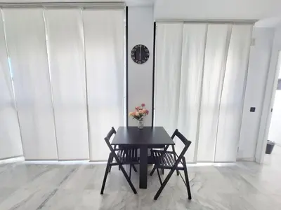 a table with two chairs and a clock on a wall at Original y Coqueto en el Centro in El Puerto de Santa María