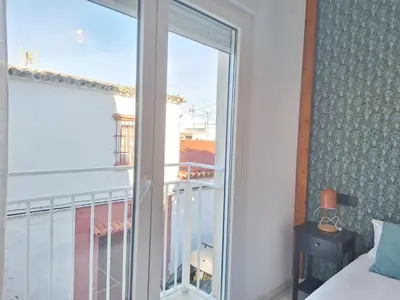 a bedroom with a window with a view of a balcony at Original y Coqueto en el Centro in El Puerto de Santa María
