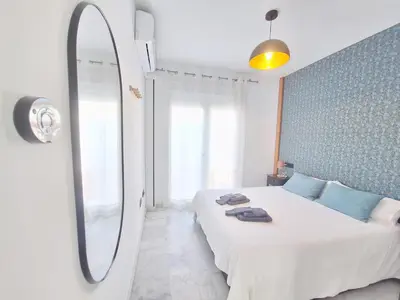 a bedroom with a bed with a mirror on the wall at Original y Coqueto en el Centro in El Puerto de Santa María