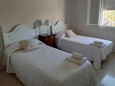 a bedroom with two beds with towels on them at El Parque 4 dormitorios wifi playa centro in Sanlúcar de Barrameda