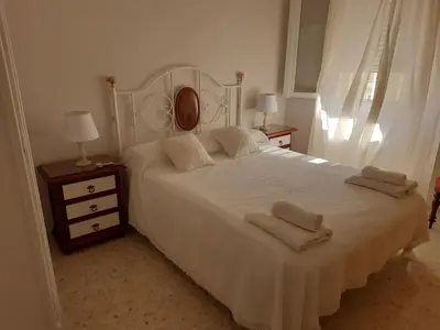 a bedroom with a white bed with two towels on it at El Parque 4 dormitorios wifi playa centro in Sanlúcar de Barrameda
