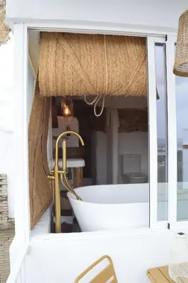 a bathroom with a bath tub in a window at Laan Arcos, casa cueva in Arcos de la Frontera
