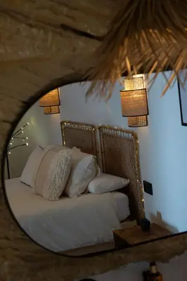 a bedroom with a bed in a mirror at Laan Arcos, casa cueva in Arcos de la Frontera