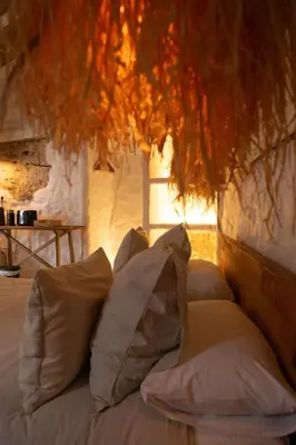 a bed with pillows sitting in a room at Laan Arcos, casa cueva in Arcos de la Frontera