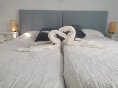 a bed with two swans made out of towels at Bonita casa cerca de la playa in Chipiona