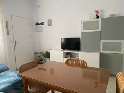 a living room with a table and a tv at Bonita casa cerca de la playa in Chipiona
