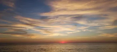 a sunset over the ocean with a cloudy sky at Bonita casa cerca de la playa in Chipiona