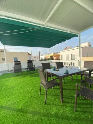 a patio with a table and chairs under a canopy at Bonita casa cerca de la playa in Chipiona