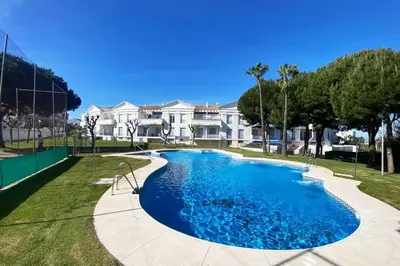 a large swimming pool in front of a house at Apartamento Jara, playa, piscina, AC, Wi-Fi in Sanlúcar de Barrameda