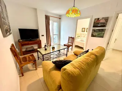 a living room with a yellow couch and a table at GATU Faro con Parking gratis, 