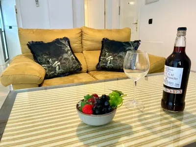a bottle of wine and a bowl of fruit on a table at GATU Faro con Parking gratis, 