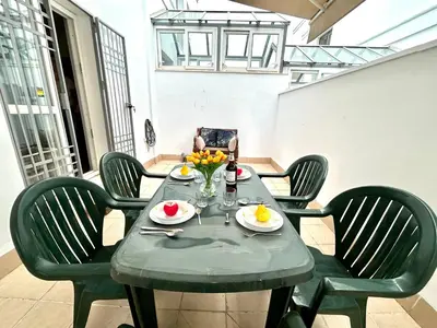 a table with chairs and a table with fruit on it at GATU Faro con Parking gratis, 