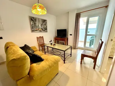 a living room with a yellow couch and a table at GATU Faro con Parking gratis, 