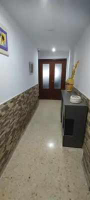 a room with a hallway with a table and a door at Doña Cora in San Fernando
