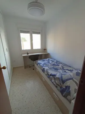 a bedroom with a bed and a desk and a window at Doña Cora in San Fernando