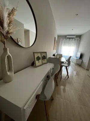 a living room with a table and a mirror at Apartamentos Modern Homes in Chiclana de la Frontera