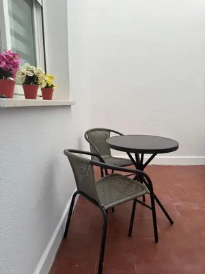 a table and a chair next to a table and a window at Apartamentos Modern Homes in Chiclana de la Frontera
