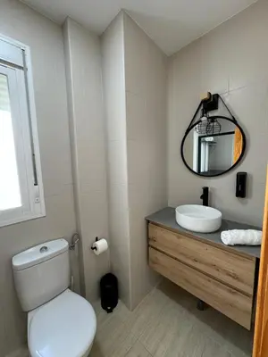a bathroom with a toilet and a sink and a mirror at Apartamentos Modern Homes in Chiclana de la Frontera