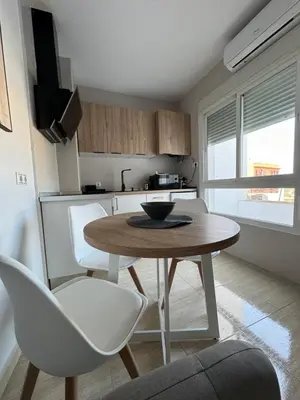 a small kitchen with a table and chairs in a room at Apartamentos Modern Homes in Chiclana de la Frontera