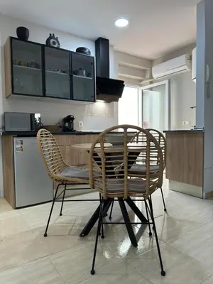 a kitchen with a dining table and two chairs at Apartamentos Modern Homes in Chiclana de la Frontera