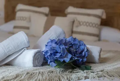 a bouquet of blue flowers on a bed with towels at Alcazar Centrico Moderno in Jerez de la Frontera