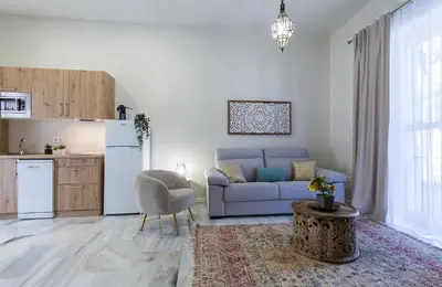 a living room with a blue couch and a kitchen at Alcazar Centrico Moderno in Jerez de la Frontera