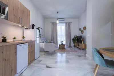 a kitchen with a refrigerator and a living room at Alcazar Centrico Moderno in Jerez de la Frontera