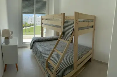 a wooden bunk bed in a room with a window at Apartamento en Costa Ballena in Chipiona