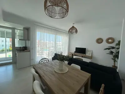 a living room with a dining room table and a couch at Apartamento en Costa Ballena in Chipiona