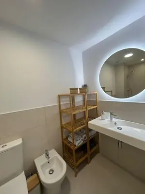 a bathroom with a toilet and a sink and a mirror at Apartamento en Costa Ballena in Chipiona