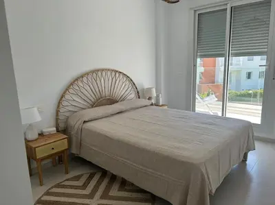 a bedroom with a large bed with a large window at Apartamento en Costa Ballena in Chipiona