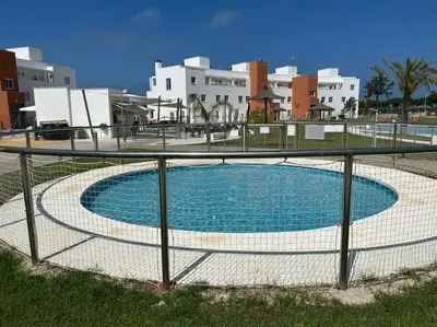 a fence around a swimming pool in front of buildings at Apartamento en Costa Ballena in Chipiona