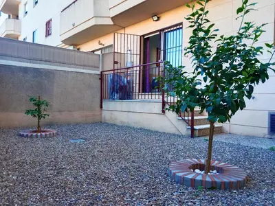 a building with two trees in front of a building at Tempul Garden Suite in Jerez de la Frontera