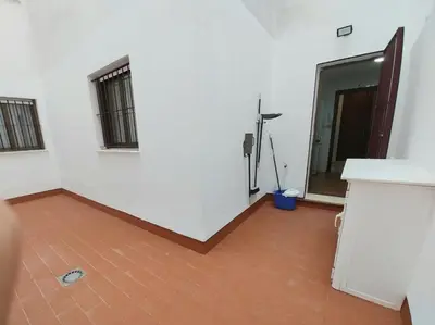 a room with white walls and a wooden floor at Tempul Garden Suite in Jerez de la Frontera