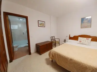 a bedroom with a bed and a bathroom with a toilet at Tempul Garden Suite in Jerez de la Frontera