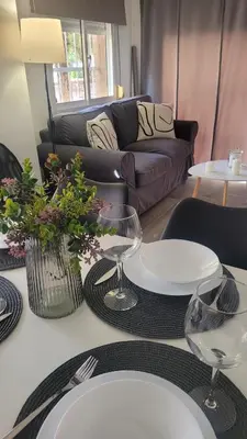 a living room with a table with plates and glasses at Apartamento Viñedos de Librado in Jerez de la Frontera