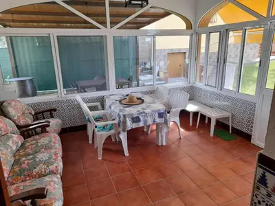 a living room with a table and chairs and windows at Casa La Laguneta in Arcos de la Frontera
