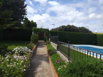 a garden with flowers and a fence next to a pool at Casa La Laguneta in Arcos de la Frontera