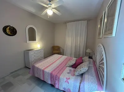 a bedroom with a bed and a ceiling fan at La Marina, apartamento in Sanlúcar de Barrameda