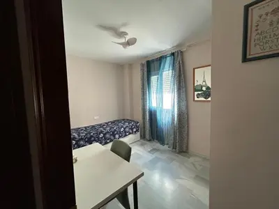 a room with a couch and a table and a window at La Marina, apartamento in Sanlúcar de Barrameda