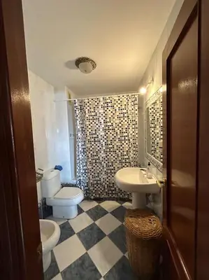 a bathroom with a sink and a toilet and a shower at La Marina, apartamento in Sanlúcar de Barrameda