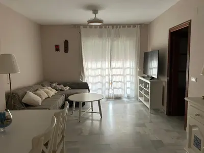 a living room with a couch and a table at La Marina, apartamento in Sanlúcar de Barrameda