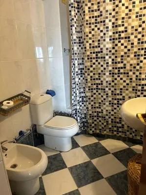 a bathroom with a toilet and a sink at La Marina, apartamento in Sanlúcar de Barrameda