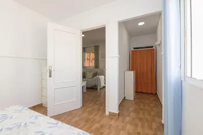a bedroom with a white door and a room with a bed at Jopamar in Chiclana de la Frontera