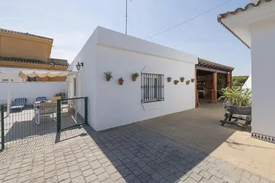 a white house with a courtyard with a fence at Jopamar in Chiclana de la Frontera